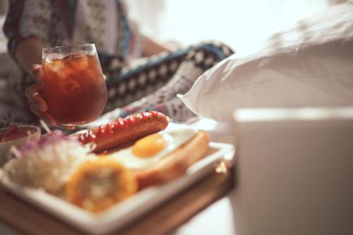 a person holding a drink and a plate of food at Kenny Stay Busan Gijang in Busan