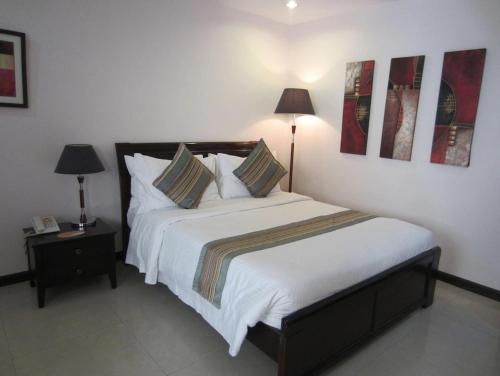 a bedroom with a bed with white sheets and pillows at The Suites at Calle Nueva in Bacolod