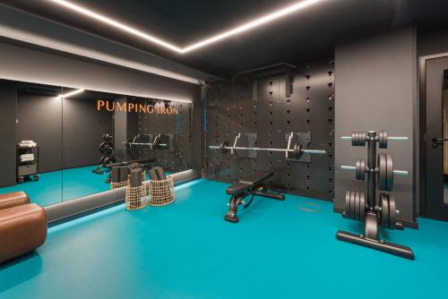a gym with dumbbells and machines in it at EmiLu Design Hotel in Stuttgart