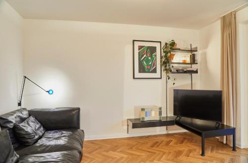 a living room with a couch and a flat screen tv at Gemütliche Wohnung mit Balkon in Deidesheim