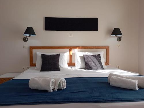 a bedroom with a large bed with two towels on it at Toni´s Guesthouse in Kavos