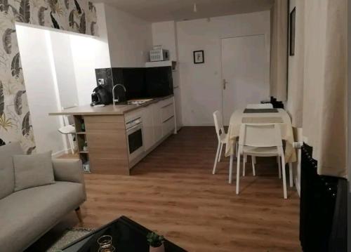 a kitchen and a living room with a table and chairs at Joli T2 près de Rennes in Vezin-le-Coquet