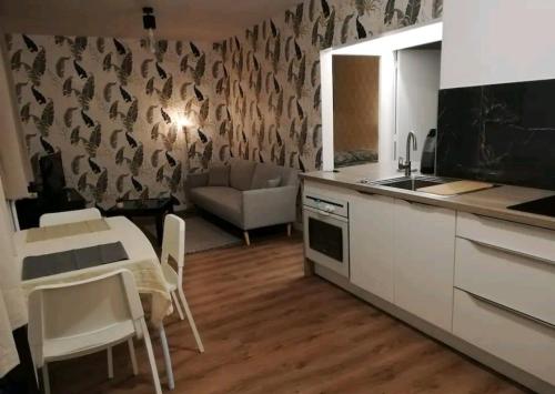 a kitchen and living room with a table and a sink at Joli T2 près de Rennes in Vezin-le-Coquet