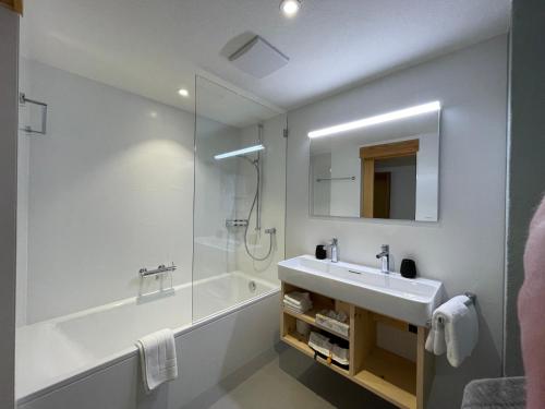 a bathroom with a sink and a shower and a tub at Chesa La Furia in Pontresina