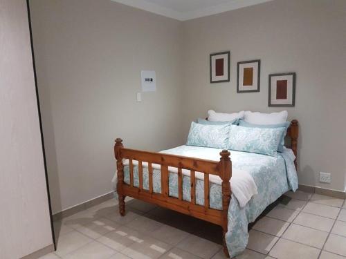 Pretoria的住宿－Genie's Nest Ooie 3，一间卧室,卧室内配有一张木床