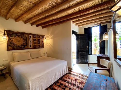 een slaapkamer met een wit bed in een kamer met een raam bij Maison Du Tresor in Marrakesh