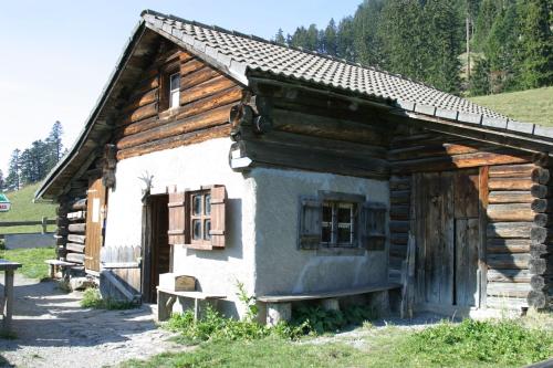 a small log cabin with a bench in front of it at Swiss Heidi Hotel in Maienfeld
