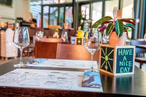 a table with two wine glasses and a menu at Swiss Heidi Hotel in Maienfeld