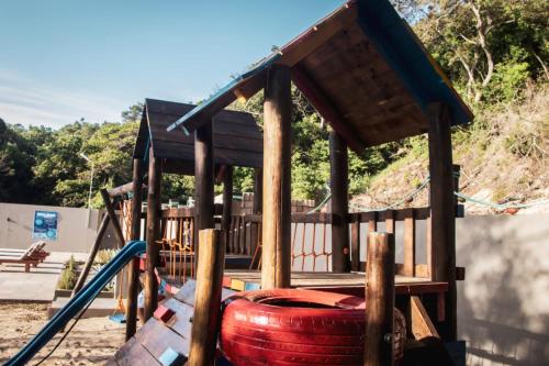 a playground with a red barrel and a wooden structure at WHITE SHARK RESORT in Ponta do Ouro
