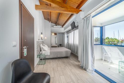 Ianos Bay في ليفكادا تاون: غرفة نوم بسرير ونافذة كبيرة