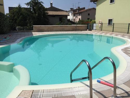 a large swimming pool with blue water at Casa Cariza-Appartamento con piscina in Colà di Lazise