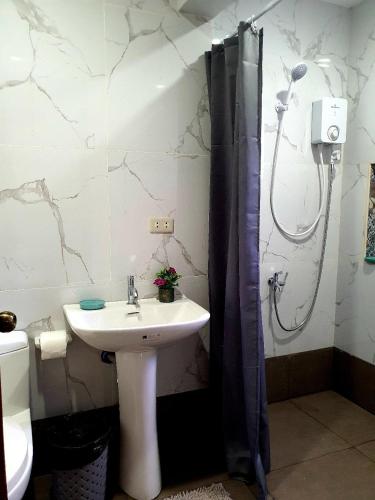 a bathroom with a sink and a shower at Luis miguel's place in Dumaguete
