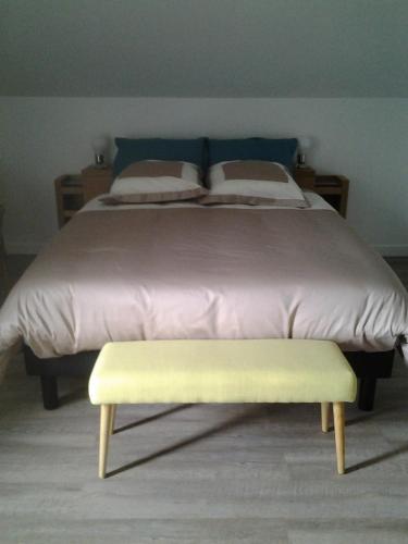 a bed with a yellow bench in a bedroom at La Maison Mirabeau in Verdun