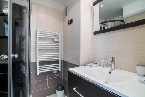 une salle de bain avec un lavabo et une douche dans l'établissement Le Carla, à Cannes