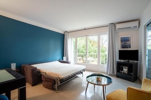 une chambre avec un lit et un mur bleu dans l'établissement Le Carla, à Cannes
