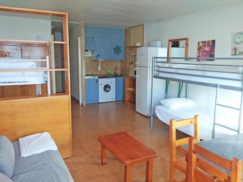 a small room with two bunk beds and a table at Apartamentos Lake Placid 3000 in Pas de la Casa