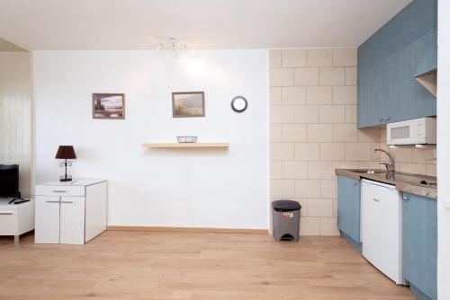 a kitchen with blue cabinets and a white wall at Apartamentos Lake Placid 3000 in Pas de la Casa