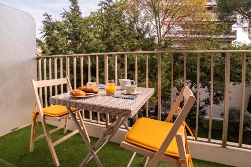 - une table et des chaises sur un balcon avec du jus d'orange dans l'établissement Le Carla, à Cannes