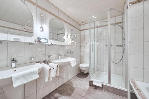 a bathroom with a shower and a sink and a toilet at Hotel Ritter Badenweiler in Badenweiler