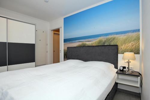 a bedroom with a bed and a view of the beach at Linden-Palais Wohnung 33 in Heiligendamm