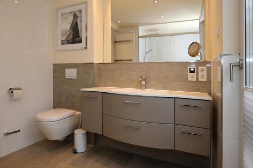 ein Bad mit einem Waschbecken und einem WC in der Unterkunft Linden-Palais Wohnung 33 in Heiligendamm