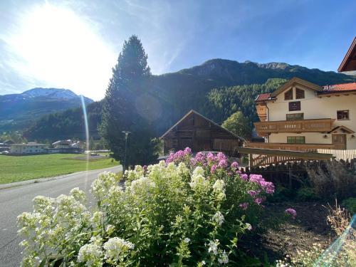 a garden with flowers in front of a building at Alpine Lodge Sölden - Chalet & Apart in Sölden