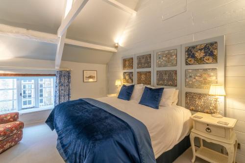 um quarto com uma cama grande e uma janela em Farthingdales em Burford