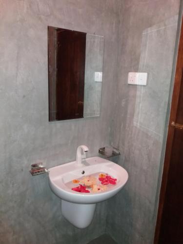 a white sink in a bathroom with a mirror at Cashew Villa Hiriketiya in Hiriketiya