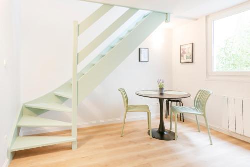 une salle à manger avec une table et des chaises et un escalier dans l'établissement Les Nuances de Julien - Appt au coeur de Nancy, à Nancy