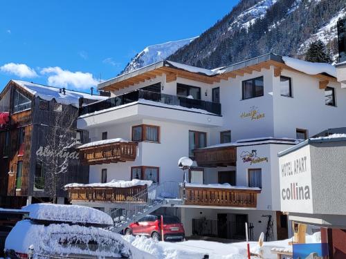 a large white building with snow on the ground at Pension Lenz in Ischgl
