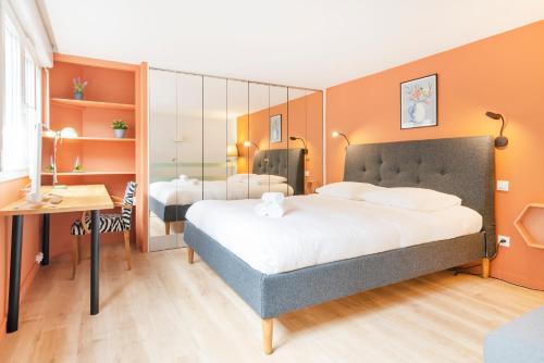 a bedroom with a large bed and a desk at Les Nuances de Julien in Nancy