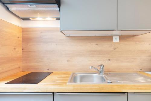 a kitchen with a sink and a wooden counter top at Les Nuances de Julien in Nancy