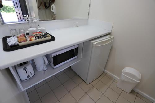 a bathroom with a counter with a sink and a microwave at Reign Inn Newcastle in Newcastle