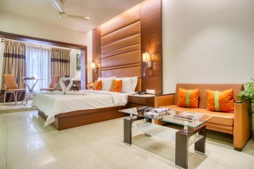 um quarto de hotel com uma cama e um sofá em The Samilton em Calcutá