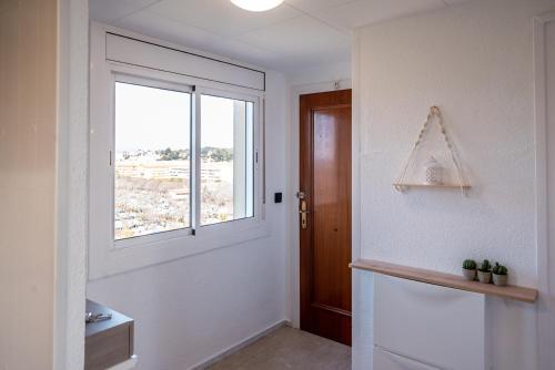 a white hallway with a window and a door at Apartamento Consul Park in Blanes