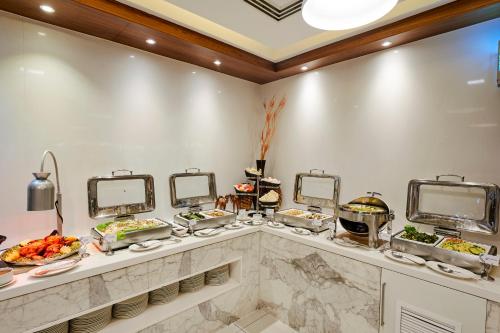 a buffet line with dishes of food and mirrors at Citymax Sharjah in Sharjah