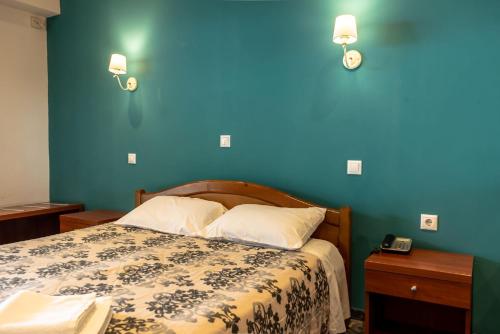 sypialnia z łóżkiem z niebieską ścianą w obiekcie Telis Hotel w mieście Ejo