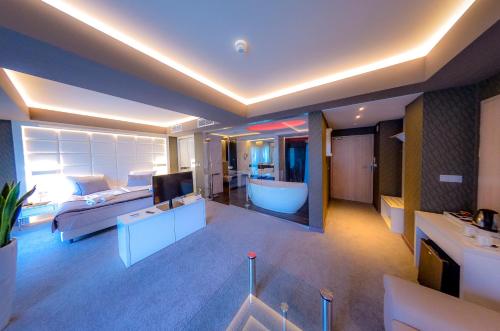 ein großes Wohnzimmer mit einer Badewanne und einem TV in der Unterkunft Hotel Astone Conference & Spa in Lubin