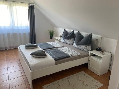 a bedroom with a bed with pillows on it at Munkácsy Apartmanok in Balatonfenyves