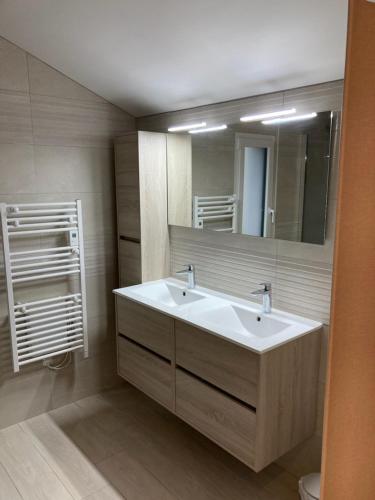 une salle de bain avec un lavabo blanc et un miroir dans l'établissement GITES DE KERFETAN, à Moréac