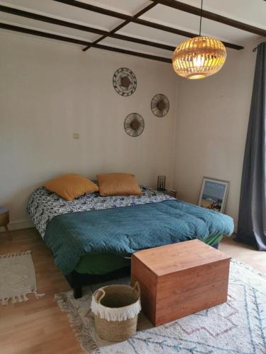 - une chambre avec un lit doté d'une couette bleue et d'une table dans l'établissement maison de vacances Mont de Marsan, à Lucbardez-et-Bargues