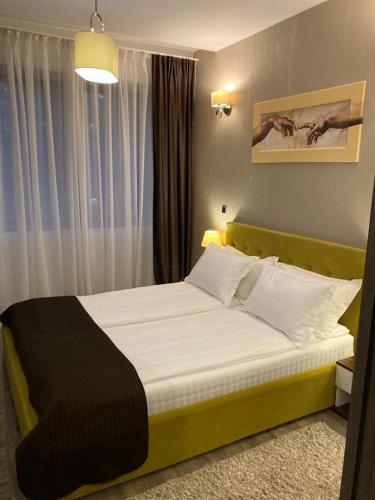 a bedroom with a large bed with a yellow headboard at Silver Luxury 6 in Poiana Brasov