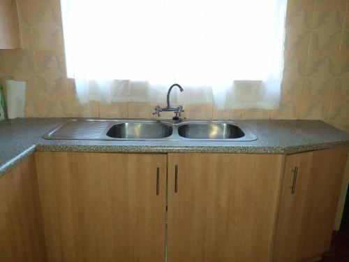a sink in a kitchen with a window at The Best Green Garden Guest House in Harare in Harare