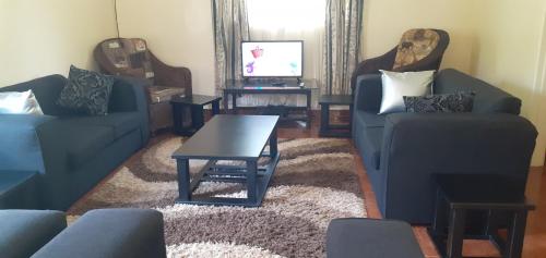 a living room with two couches and a coffee table at The Best Green Garden Guest House in Harare in Harare