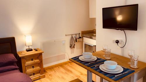 a living room with a table and a tv at Private Detached Annex in Isleham Village in Isleham
