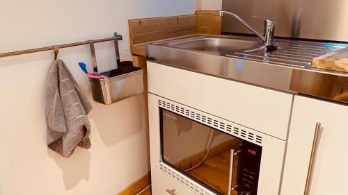 a small kitchen with a sink and a stove at Private Detached Annex in Isleham Village in Isleham