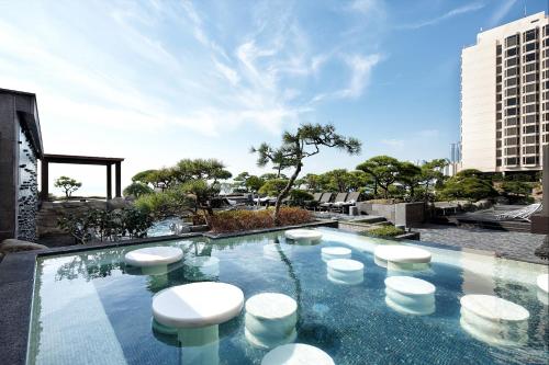 a swimming pool with stools on top of a building at Paradise Hotel Busan in Busan