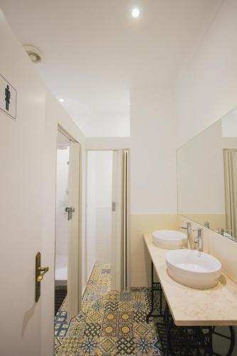 a bathroom with two sinks and a shower at PTM DownTown Hostel&Suites in Portimão