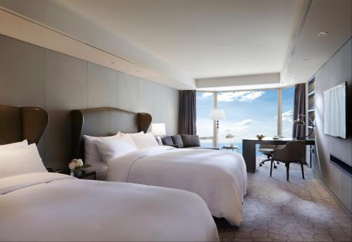 a hotel room with two beds and a desk at Paradise Hotel Busan in Busan