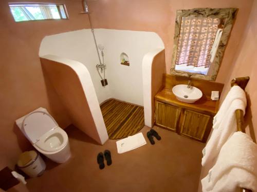 małą łazienkę z toaletą i umywalką w obiekcie Murchison Falls Bamboo Village w mieście Murchison Falls National Park